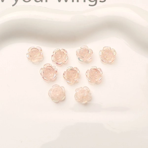 Macro detail of 10mm iridescent pink resin rose flower charms for DIY nail art design