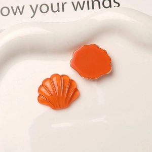 Makroaufnahme von orangefarbenen Harzmuscheln für DIY-Schuhe mit Vorder- und Rückseitenansicht