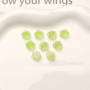 Macro view of nine 10mm aurora green resin camellia flowers on a white ceramic tray