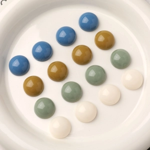 Cabujones redondos de acrílico colorido en bandeja blanca para creación de joyas DIY