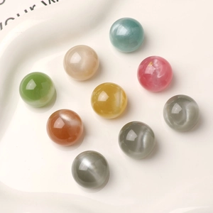 Macro shot of 16mm shimmering starry resin beads with cat-eye effect in various colors