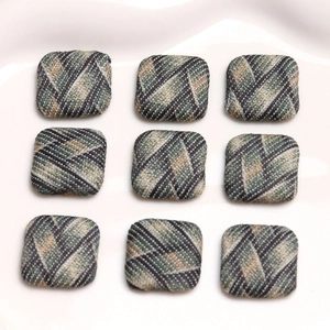 Close-up of nine square plaid fabric buttons with British tweed pattern in a 3x3 grid