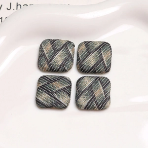 Macro shot of British style plaid fabric square buttons on a white ceramic display tray