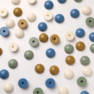 Detalle de cuentas redondas de resina acrílica de colores con agujeros para joyería DIY