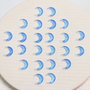 Makroansicht blauer halbtransparenter Harzmonde mit Glitzereffekt für DIY Schmuckdesign