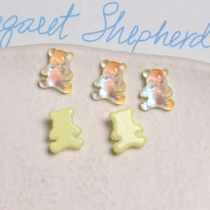 Nahaufnahme von fünf schillernden und gelben Mini-Harzbären für DIY-Nagelkunst und Design