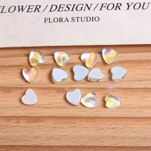 Macro view of aurora crystal heart beads for nail art and DIY jewelry on wood surface