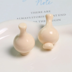 Dettaglio di ciondoli in resina bianco crema per gioielli DIY con finitura lucida