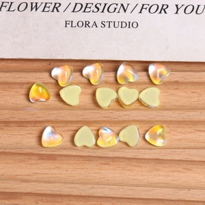 Macro view of aurora iridescent heart-shaped glass beads for DIY nail art and craft decor