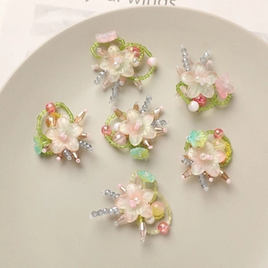 Macro detail of six handmade gradient glass flower charms for DIY jewelry accessories