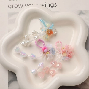 Macro detail of handmade crystal lily of the valley pendants in blue, pink and purple