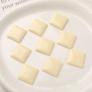 Macro shot of off-white square resin cabochons for DIY earring and jewelry making