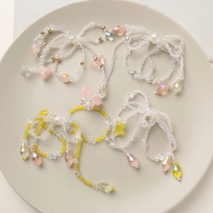 Macro detail of handmade beaded crystal bow pendants with colorful charms and pearls