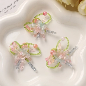 Macro shot of gradient glass flower charms with pink and blue beads for DIY jewelry making