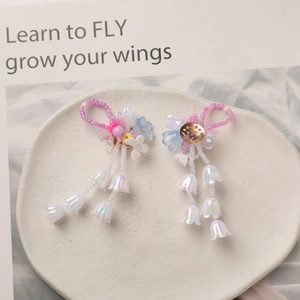 Macro shot of lily of the valley earrings with colorful beads and flower tassels