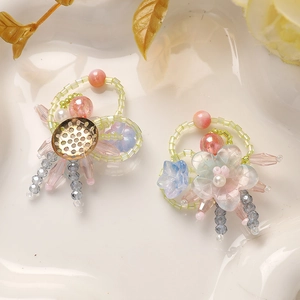 Detail of handmade gradient glass flower pendants with intricate beads and wire work