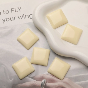 Close-up of square cream resin charms for DIY jewelry and hair accessory making