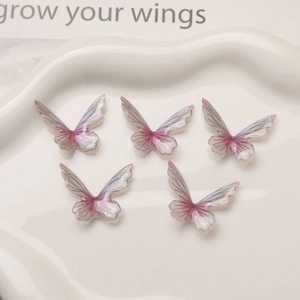 5pcs gradient resin butterfly charms with glitter edges on a decorative white dish