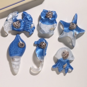 Macro view of blue ocean theme resin charms featuring seahorse, starfish and jellyfish shapes