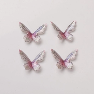 Macro detail of DIY butterfly charms with pink gradient glitter and 3D textured wings