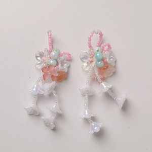 Macro detail of handmade gradient lily of the valley floral charm with colorful beads