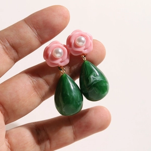 Detail of pink resin flower earrings with pearl accents and green marble teardrop pendants