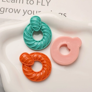 Vue rapprochée de breloques en résine spirale colorées pour bijoux DIY sur plat