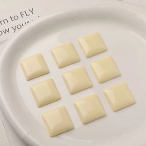Square cream resin charms for DIY earrings and hair accessories in a ceramic tray