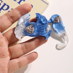 Macro detail of resin sea creature charms featuring embedded real shells and pearl finish