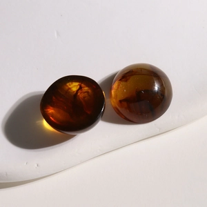 Vue macro de deux cabochons en résine ambrée à texture translucide pour la création de bijoux