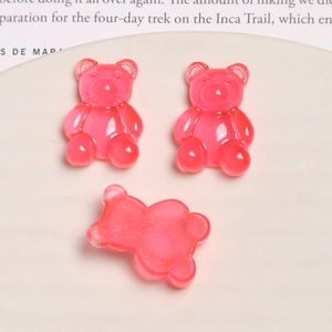 Macro shot of three pink translucent resin gummy bears for DIY accessories in a ceramic tray