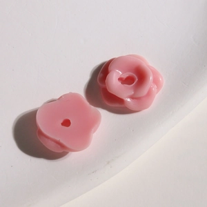 Macro detail of small pink resin flower beads with hollow holes for DIY jewelry