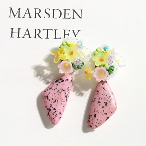 Macro detail of floral beaded earrings with pink speckled triangle stone charms