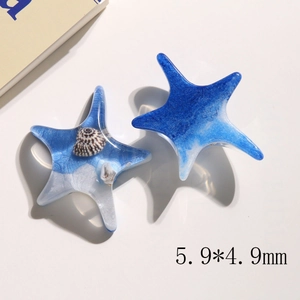 Macro view of blue starfish resin charms with shell inlay and glitter details