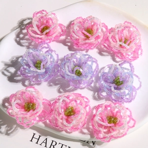 Detailed view of handmade beaded hibiscus flowers in pink and purple colors