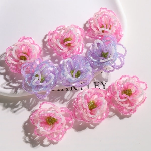 Macro detail of handmade gradient beaded hibiscus flower charm with pink and purple beads