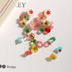 Detail of colorful crystal beaded floral tassel earrings with 3D resin flowers