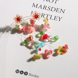 Detail of beaded floral earrings featuring colorful resin petals and faceted crystal beads