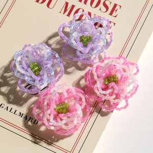 Handmade beaded gradient flower accessories in purple and pink tones with green centers