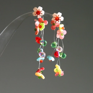 Macro shot of colorful beaded flower tassel earrings with crystals and resin petals