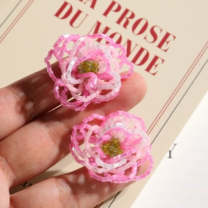 Detailed view of handcrafted pink beaded floral accessories with green center accents