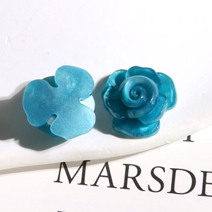 Gros plan de breloques fleurs en résine bleu ciel avec paillettes nacrées pour bijoux DIY