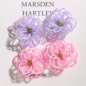 Detail of handcrafted beaded floral charms in soft gradient purple and pink hues