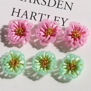 Handmade woven bead flower charms in pink and mint green with golden stamen detail