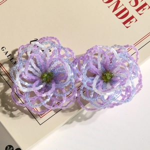 Detailed close-up of handmade beaded gradient flower accessory on vintage French book