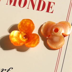 Dettaglio macro di perla a tulipano in acrilico arancione con glitter per gioielli DIY