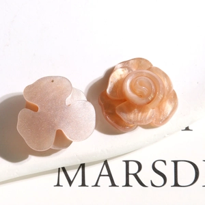 Détail de breloques en résine rose orangé pailleté camélia et rose pour boucles d'oreilles