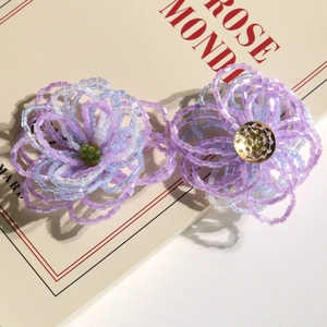 Macro detail of handmade gradient hibiscus beaded flower charms for jewelry making