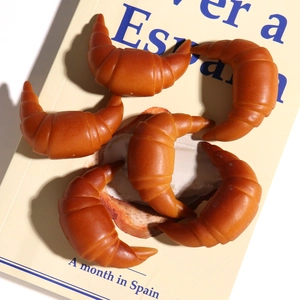 Vista dettagliata di cinque croissant realistici in resina su un libro vintage per DIY