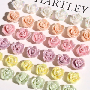 Close-up of colorful iridescent mini resin roses for DIY earrings and jewelry crafts